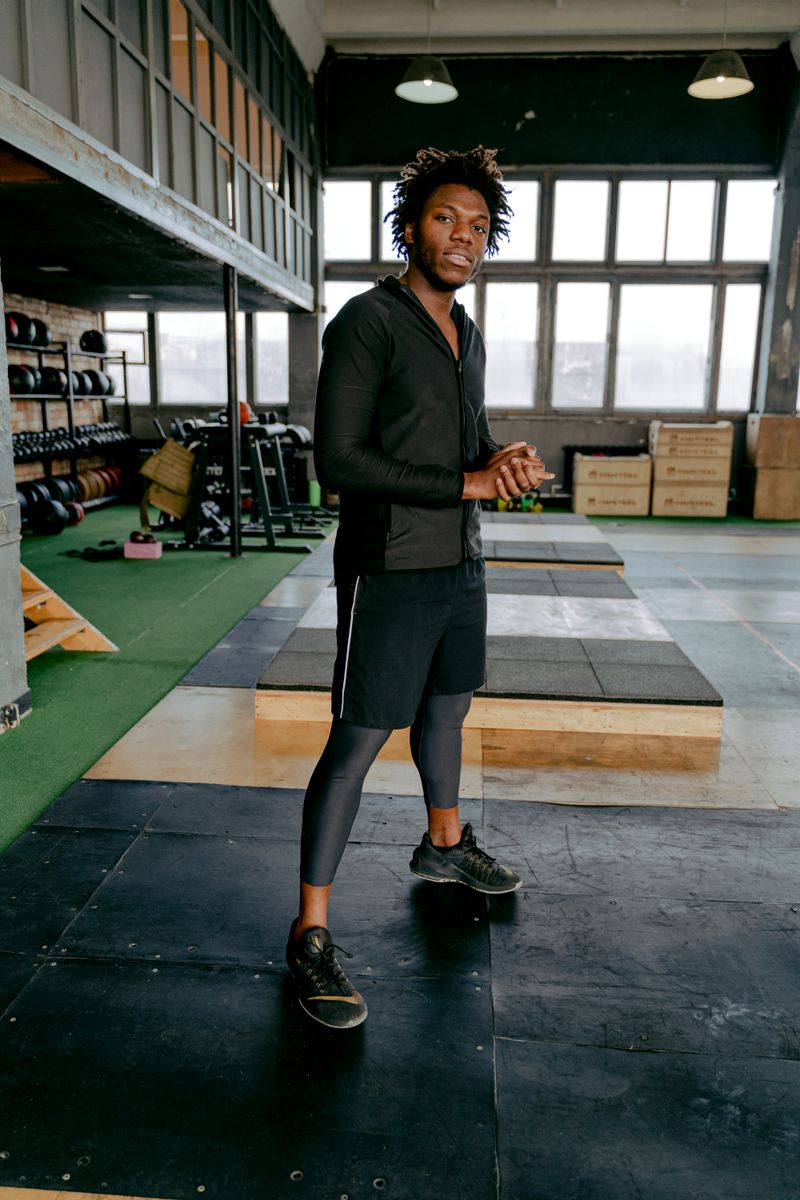 Black man standing confidently in a modern fitness studio